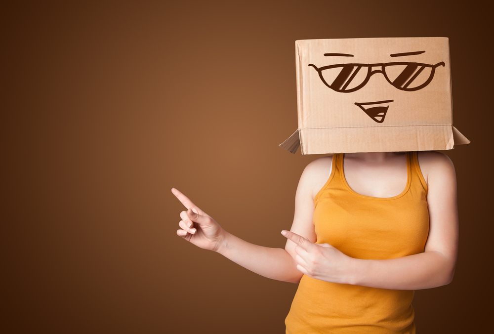 Young lady standing and gesturing with a cardboard box on her head with smiley face